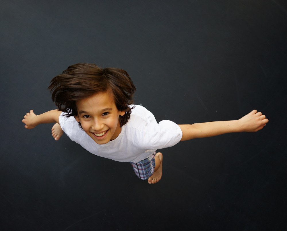 Child jumping on trampoline, high angle-1