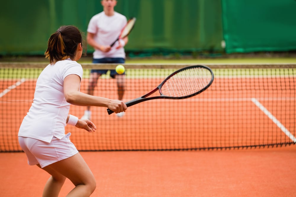 Tennis players playing a match on the court on a sunny day