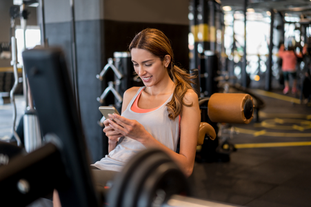 Woman on mobile app in gym
